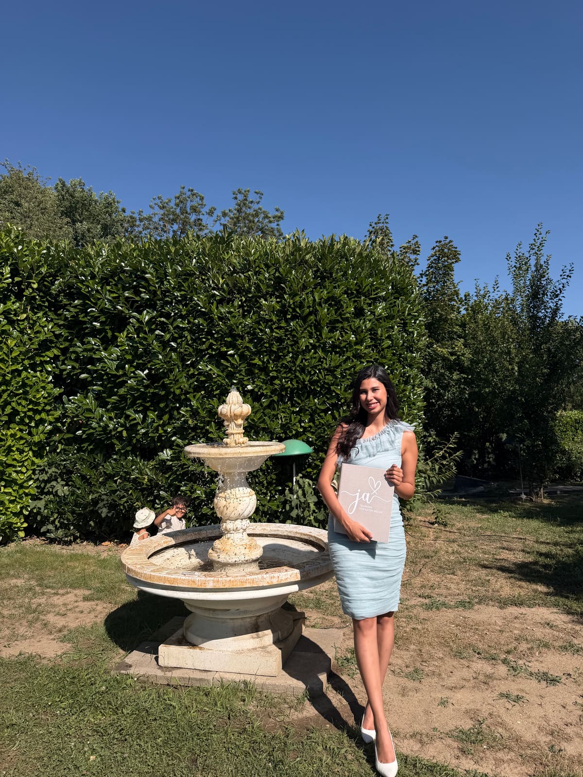 Ilayda, freie Traurednerin, mit der Redemappe am Springbrunnen der Trauungslocation